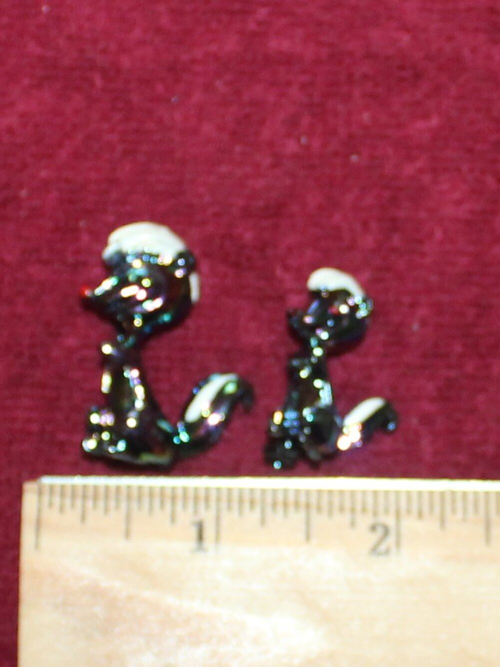 Vintage skunk scatter pins or brooches featuring iridescent bodies